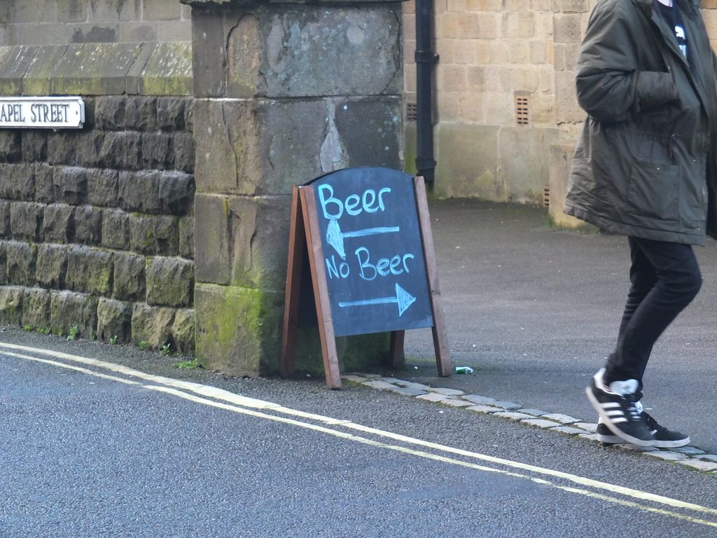 A sign between a church and a pub in Buxton Buxton - DSCF2527.jpg
